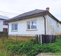 A family house with a fence, facade, and garden in the countryside, ideal for a cottage.