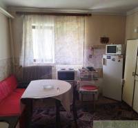 A kitchen in a family house with retro furniture, a stove, and a refrigerator.