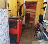 Boiler in the family house boiler room, wood, tools, storage shelves, and basket.