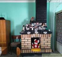 A brick fireplace in a family house surrounded by photos, furniture, and Easter decorations.