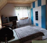 Attic room in a family house with a wardrobe, desk, and dumbbell.
