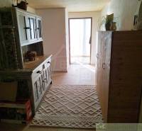 A hallway in a family house with a carpet runner and rustic furniture.