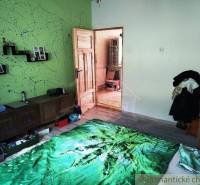 A room with colorful decorations and a green throw captures a cozy family home.