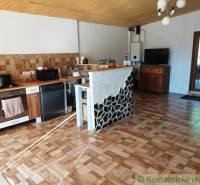 A kitchen in a family house with a wood-paneled ceiling and a tiled floor.