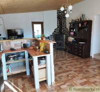 A family house with a kitchen, wooden floor, tiles, and wooden ceiling paneling.