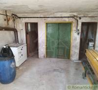 In the picture, there is a workshop with wooden elements and a blue barrel near the cabin.