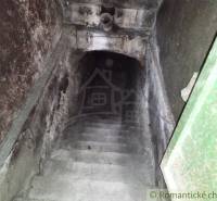 Stone staircase leading to a dark basement, ideal for a cottage or cabin.