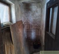 A narrow room with wood and an old wall, suitable for renovating a cottage.