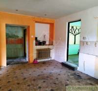 The interior of the cabin with tiling, protruding heating, and a visible transition to another room.