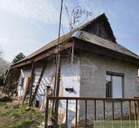Traditional family house with a wooden roof, garden, fencing, and a rural atmosphere.