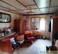 A room in a family house with furniture, decorations, and a large window offers comfort.