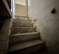 Old concrete stairs leading to the door inside a family house.