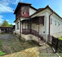 A family house with a spacious yard and a wooden arcade, ideal for living.