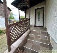 Entrance stairs with wooden railing leading to a family house.