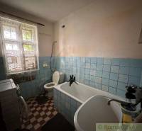 The bathroom with a bathtub, sink, and toilet in the family house is adorned with blue tiles.