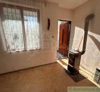 In the picture, there is a room and a cottage with a stove and a window.