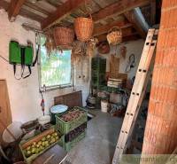 The picture shows a cozy cabin with a wooden ceiling, baskets, and stored fruit.