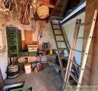 A cottage with ladders, dried onions, and storage boxes in the warehouse.