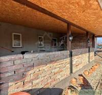 A veranda with stone walls and decorative clay pots in a family house.