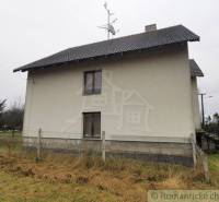 The image shows a family house with a sloped roof, fencing, and a visible satellite dish.