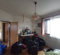 A living room in a family house with a chandelier, a television, and lots of bags on the floor.