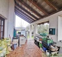 A veranda of a family house with storage space and a view of the garden.