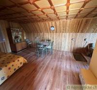 Attic room with wooden paneling, a dining table, and a comfortable space in a family house.