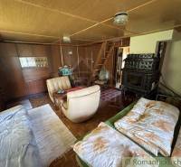 Living room in a family house, antique fireplace, comfortable couch, wooden stairs, warm atmosphere.