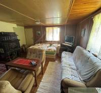 Living room in a family house with sofas, television, and a tiled stove.