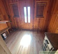 Wooden paneling in the interior, two windows, stove, family house.
