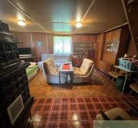 Living room of a family house with a sofa, stove, and stairs, in retro style.