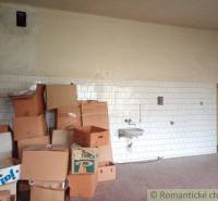Room with a sink and many cardboard boxes in the corner of a family house.