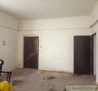 Spacious room with white walls in an older family house, open door.
