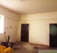 Room with worn-out walls, back door leading out of the family house.