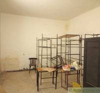 A room with metal shelves, a chair, and a table. It can be used for a family house.