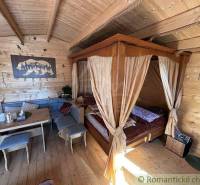 A wooden room with a hand-carved bed, table, and decorations, ideal for a family home.