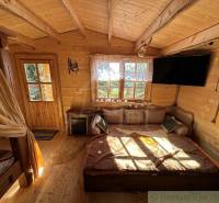 Interior of a wooden cabin with a couch, TV, and decorations, ideal for a family home.