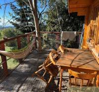 Wooden terrace, hammock, table, chairs, view of nature, family house.