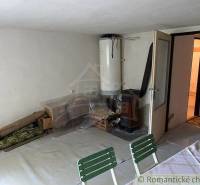 Dining room of a family house with a boiler and furniture, used for storage purposes.