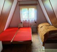 The image shows the interior of a triangular family house with beds and a window.