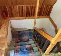 Wooden staircase in a traditional style, connected with carpets in a family house.