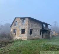 A family house in nature, an incomplete building, surrounded by a misty environment and grass.