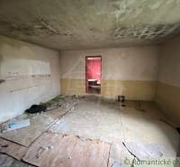 An abandoned room with damaged walls and floor in an old family house.