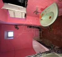 Pink bathroom and family house with a sink and a bathtub need renovation.