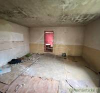 An abandoned room in a family house with a damaged floor and ceiling needs renovation.