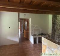 Living room with a wooden ceiling, brick fireplace, and connection to the garden house.