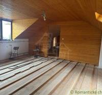An attic with wooden paneling and a view offers space for a family house.