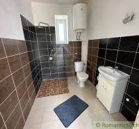 Bathroom with tiles, shower, sink, and toilet, located in a family house.