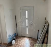 Entrance hall with white doors and stored materials in a family house.