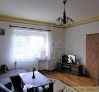 Living room of a family house with a couch, television, and curtains, ideal for relaxation.